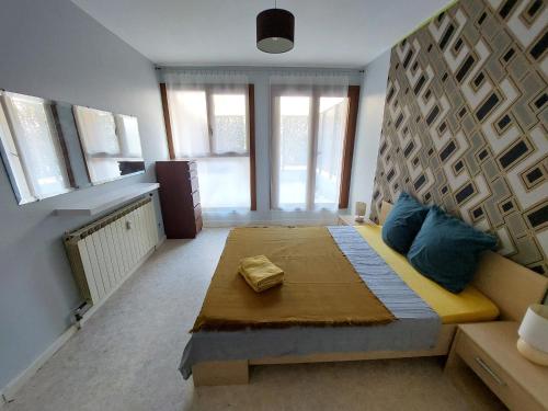 ein Schlafzimmer mit einem großen Bett mit blauen Kissen in der Unterkunft Appartement Thiers in Avignon