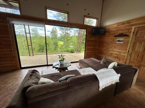 a living room with a couch and a large window at Cabañas Flor de Conquil in Villarrica