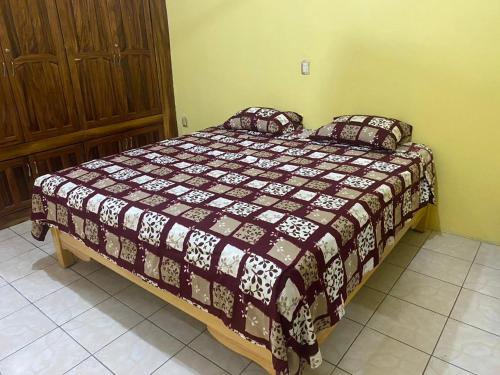 1 dormitorio con cama con edredón y almohadas en hermosa casa para vacacionar en Puerto Escondido