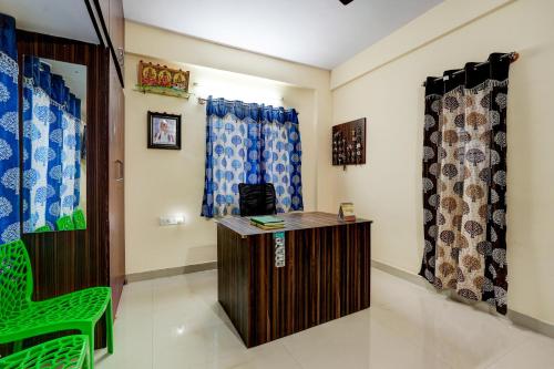 OYO Hotel SD في بانغالور: غرفة بها مكتب وكرسي وستائر