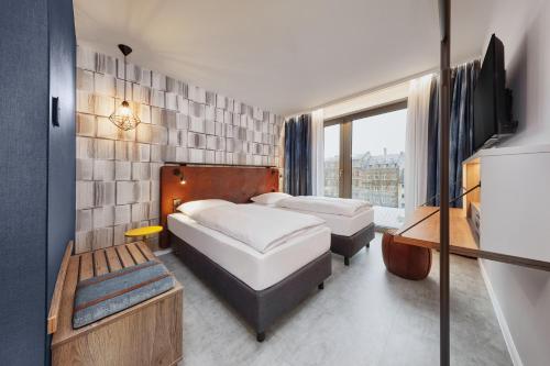 a hotel room with two beds and a window at H2 Hotel Mainz in Mainz