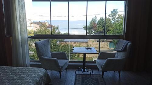 a room with a table and chairs and a large window at Gölyaka Hotel in Bursa