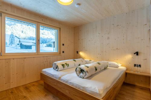 ein Schlafzimmer mit einem Bett in einem Zimmer mit einem Fenster in der Unterkunft Ferienwohnungen Nigsch in Schoppernau