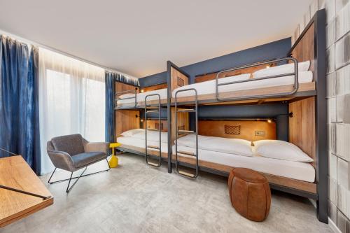 two bunk beds in a room with a desk and a chair at H2 Hotel Mainz in Mainz
