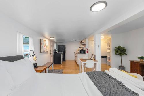 a bedroom with a white bed and a kitchen at Walk to the waterfront! The Hobbit House in Tacoma