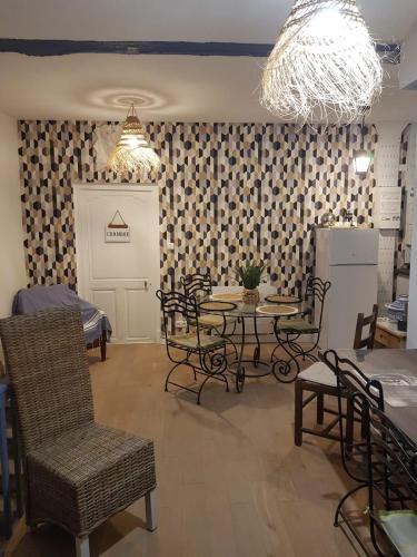 une pièce avec une table, des chaises et un lustre dans l'établissement Fenêtre sur cour du Docteur Privey - Secure Park Bike - 3 mn Autoroute, à Tournus