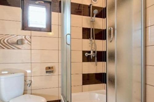 a bathroom with a shower and a toilet and a window at Holiday resort, Bobolin in Bobolin