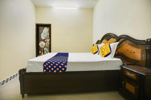 1 dormitorio con 1 cama con almohadas amarillas y azules en SPOT ON Raja Guest House, en Jalandhar