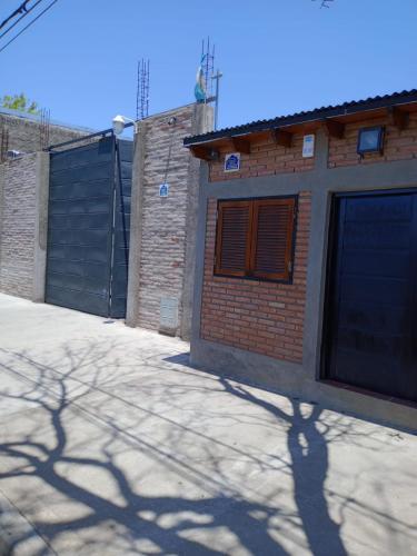 a building with two garage doors next to a sidewalk at El Refugio in San Fernando del Valle de Catamarca