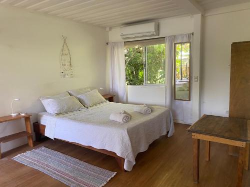 Un dormitorio con una cama grande y una ventana en Nahele Lodge, en Santa Teresa Beach