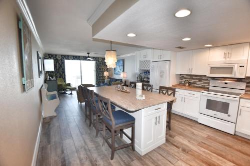 uma cozinha com armários brancos e uma mesa com cadeiras em 0309 Waters Edge Resort condo em Myrtle Beach