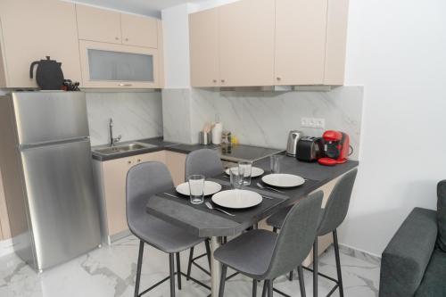 a kitchen with a table with four chairs and a refrigerator at Ermis apartment in Athens