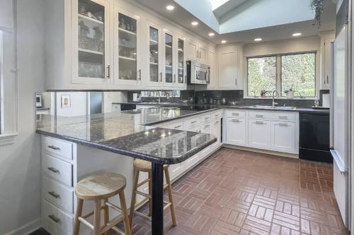 a kitchen with white cabinets and a large island with bar stools at Luke's Landing in Westport