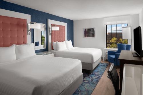 um quarto de hotel com duas camas e uma televisão em Hotel Indigo Charleston - Mount Pleasant, an IHG Hotel em Charleston