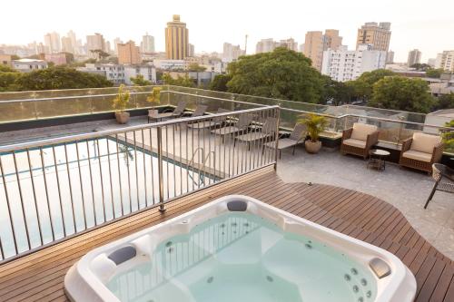 uma banheira de hidromassagem num deque com vista para a cidade em Del Rey Quality Hotel em Foz do Iguaçu