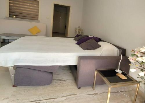 un grand lit dans une chambre avec une table dans l'établissement Studio Flat 15minutes walk from the sea, Nice - Côte D'Azure, à Nice