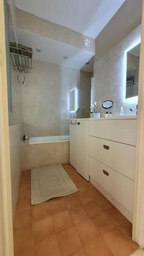 une salle de bain blanche avec une baignoire et un lavabo dans l'établissement Studio Flat 15minutes walk from the sea, Nice - Côte D'Azure, à Nice
