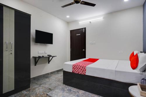 a bedroom with a bed and a flat screen tv at OYO Flagship IKON Stay and Restaurant in Hyderabad