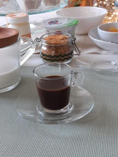 a glass cup of coffee on a plate on a table at Le Case di LuVi in Nola