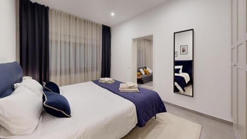 a bedroom with a large bed with blue and white pillows at STAY SMART Luxembourg Dudelange Center in Dudelange