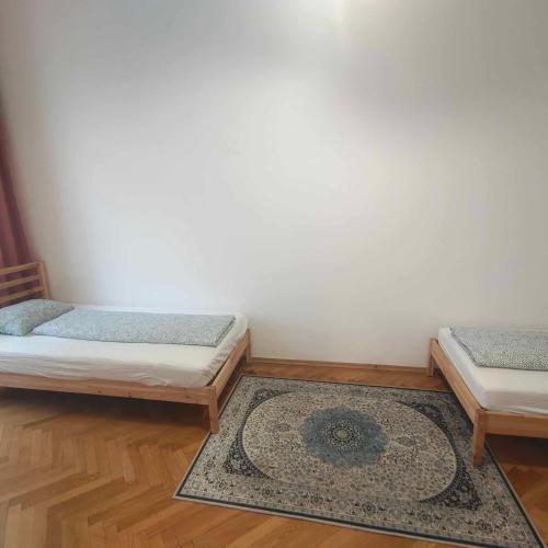 two twin beds in a room with a rug at Large 4 room apartment in the center of Vienna in Vienna