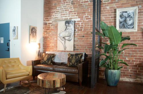a living room with a couch and a brick wall at The Old No. 77 Hotel & Chandlery in New Orleans