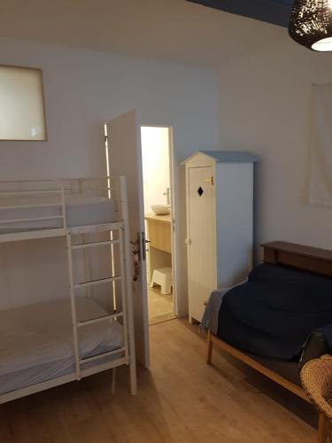 a bedroom with two bunk beds and a door to a bathroom at La suite du Docteur Privey - Free & secure Park Bike - 3mn Autoroute in Tournus