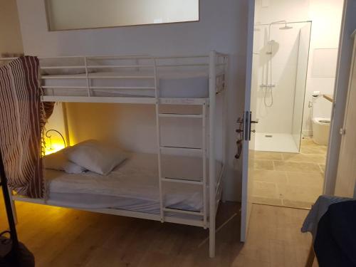 a white bunk bed in a room with a bathroom at La suite du Docteur Privey in Tournus