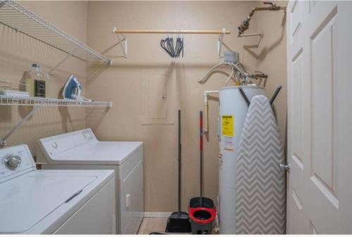 a small laundry room with a washer and dryer at Modern 2BR Oasis Pool, Gym & Parking Near Airport in Phoenix