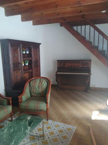 a living room with a piano and chairs and a table at Ty Gwenn la veritable Bretagne in Plésidy