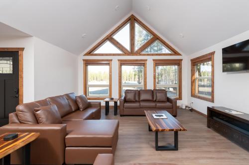 een woonkamer met lederen meubels en een groot raam bij The Evergreen Cabin in Valemount