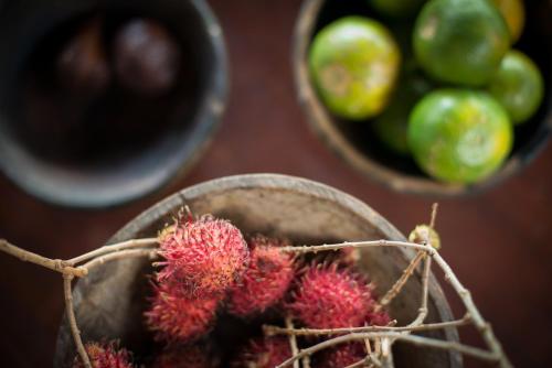 a bunch of fruit in a bowl on a table at Komaneka at Bisma Ubud in Ubud