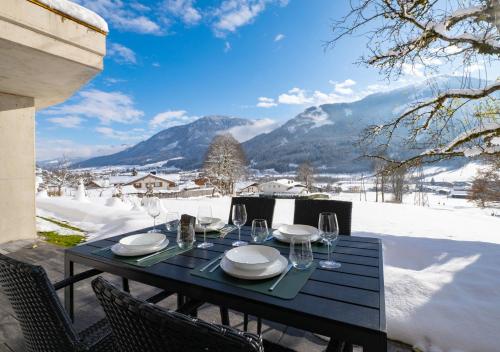 - une table noire avec des assiettes et des verres à vin dans l'établissement Alpenchalet zurHinterochsenweide SKI IN & SKI OUT, à Brixen im Thale