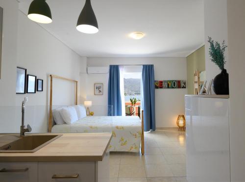 um quarto com uma cama e uma cozinha com um lavatório em Seaside Apartment em Salamina