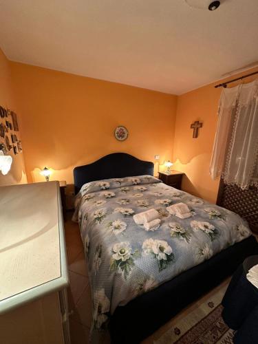 Un dormitorio con una cama con flores. en Il Regno Dei Vacanzieri en Pescocostanzo