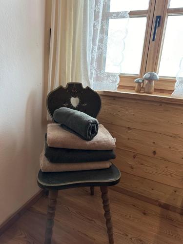 a pile of towels sitting on a chair next to a window at Peer Alm in Navis