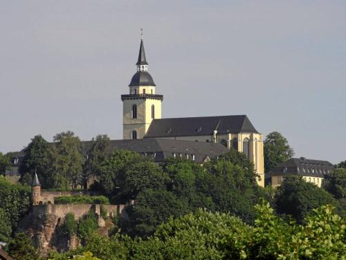 um edifício no topo de uma colina com uma torre em 3-Zimmer mitten in Siegburg em Siegburg