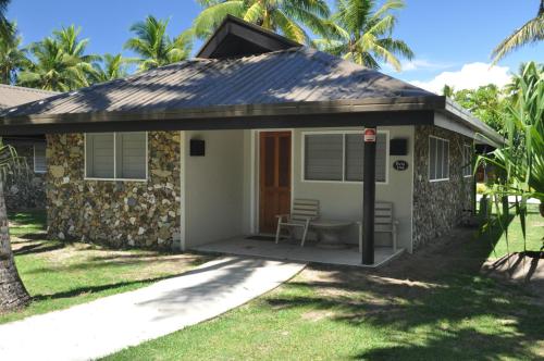 a small house with a porch and a table at Plantation Island Resort in Malolo Lailai