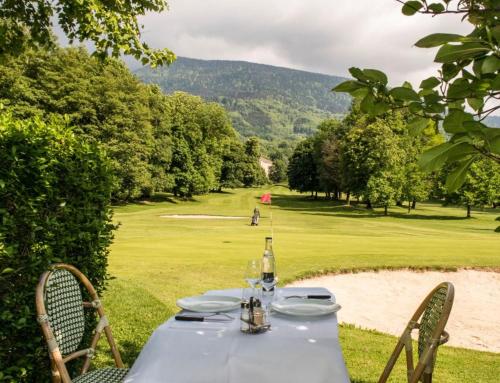 a table with a bottle of wine sitting on top of a field at L'ELGIA, gîte 3 épis, 3 étoiles in Saint-Martin-d'Uriage