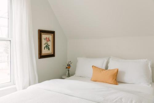 a white bed with an orange pillow on it at Town & Trail - Walkable Wellington Charmer in Wellington