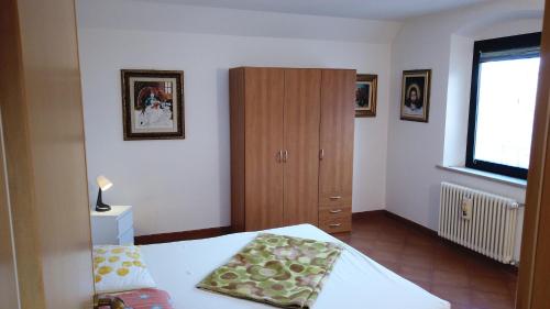 1 dormitorio con 1 cama y armario de madera en Corte degli Artisti, en Sedegliano