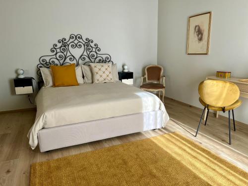 sypialnia z dużym łóżkiem i żółtym krzesłem w obiekcie Alba Room 16 w Albie