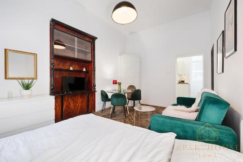 een slaapkamer met een bed en een tafel en stoelen bij Royal Style Apartment in Łódź