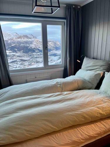 a bedroom with a bed with a view of a mountain at Skarsnuten Panorama 46 in Hemsedal