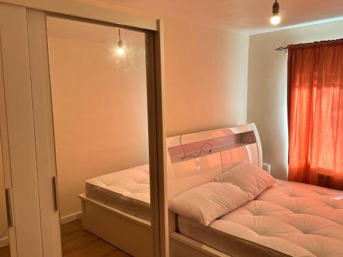 a small bedroom with a bed and a mirror at Cool &cosy in London