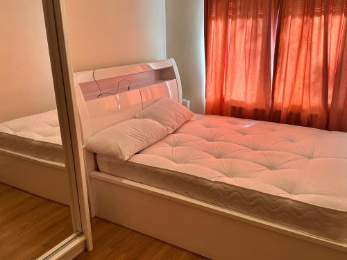 um par de camas num quarto com uma janela em Cool &cosy em Londres