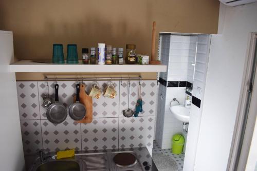 a kitchen with utensils hanging on a wall at Favela Hostel in Zagreb