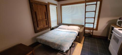 uma pequena cama num quarto com uma janela em Gondola Village by Whistler Premier em Whistler