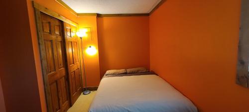 1 dormitorio pequeño con pared de color naranja en Gondola Village by Whistler Premier en Whistler