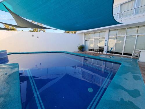 a swimming pool in front of a house at Casa Privada San Blas in San Blas